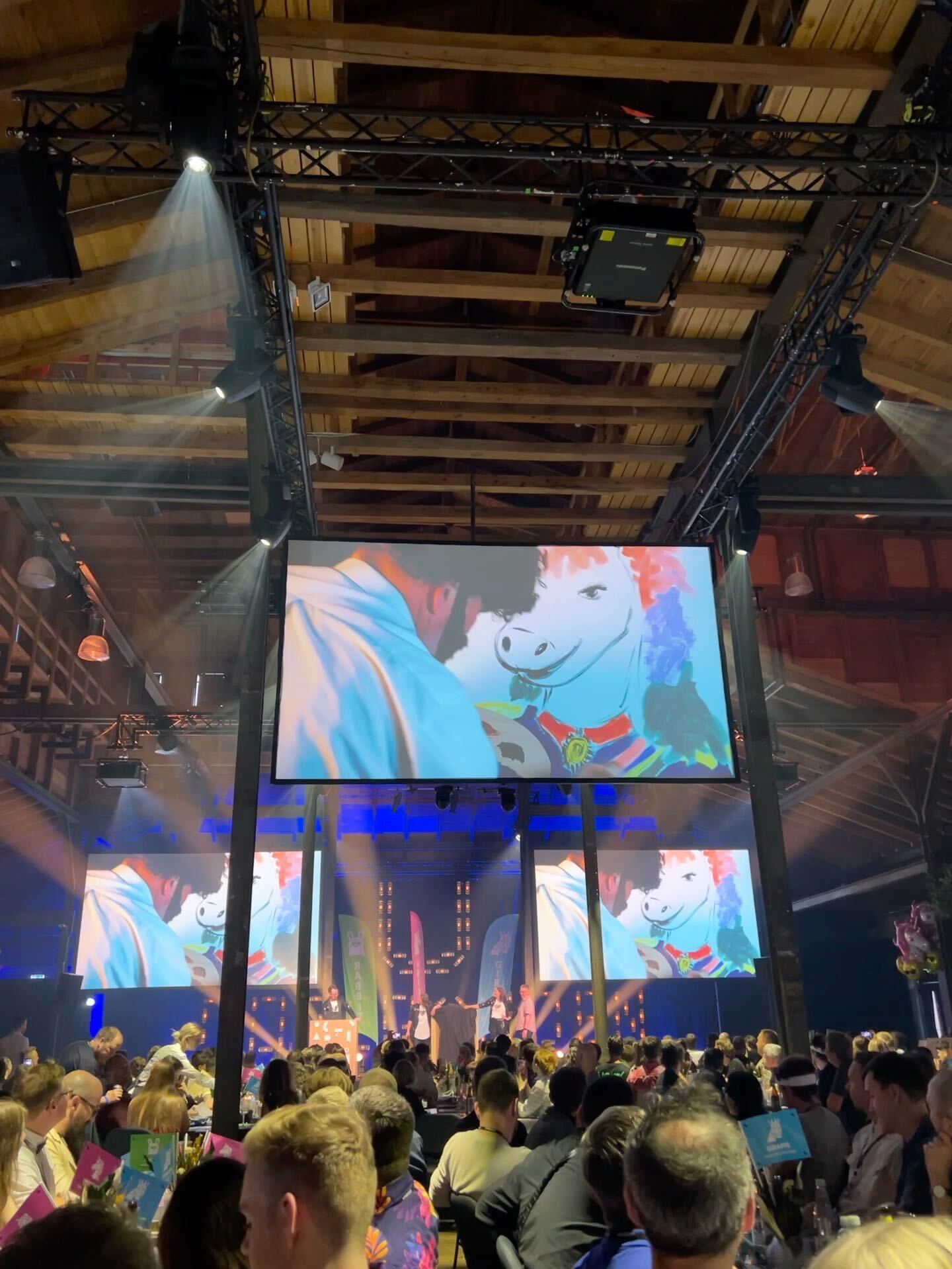 A still from a video showing someone dressed as Bob Ross painting a colorful unicorn.